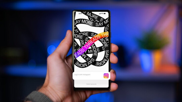 Hand Holding a Phone with Open Threads App